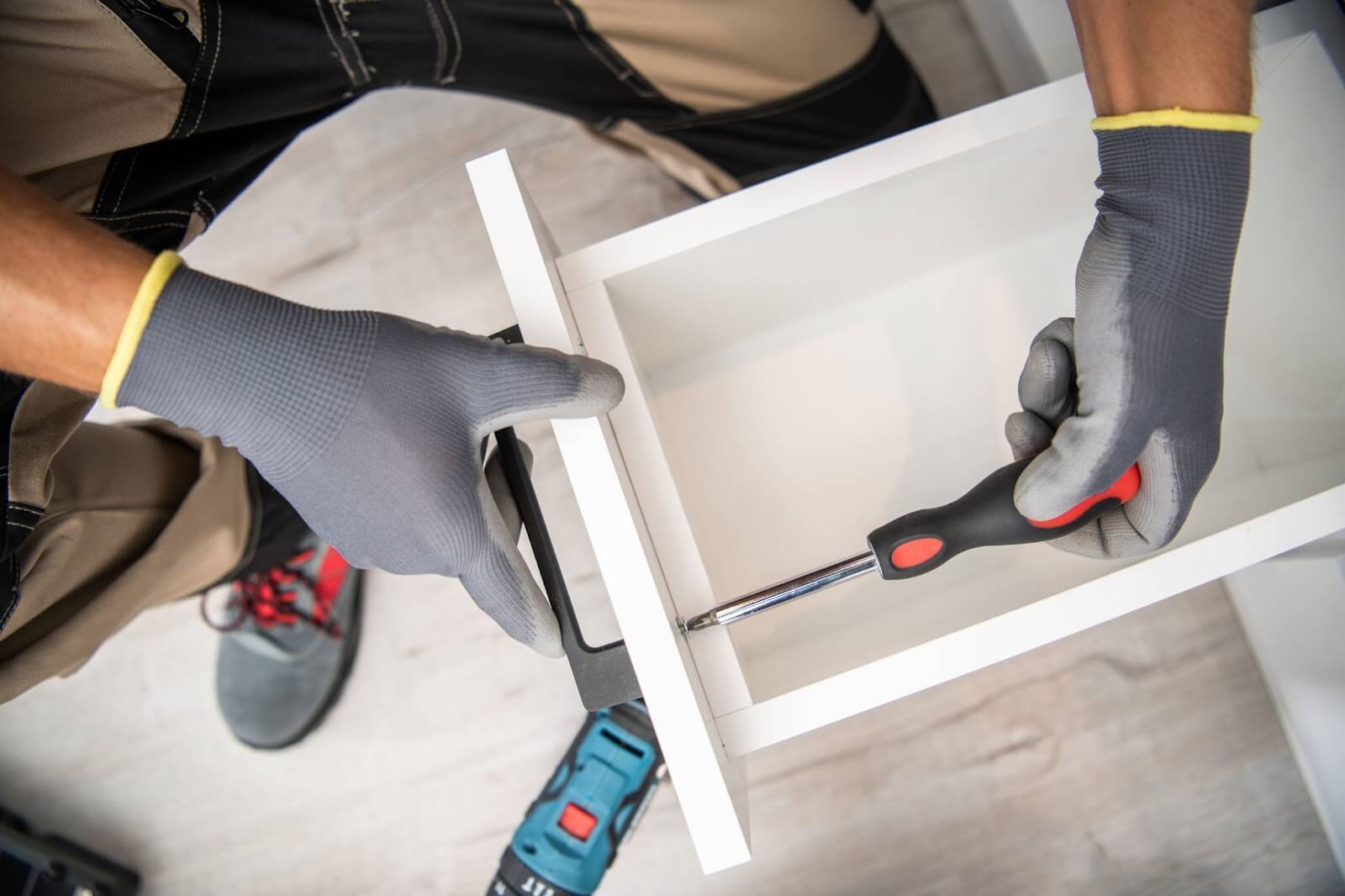 Man with gloves and pliers using screwdriver for Cabinet Express Installation